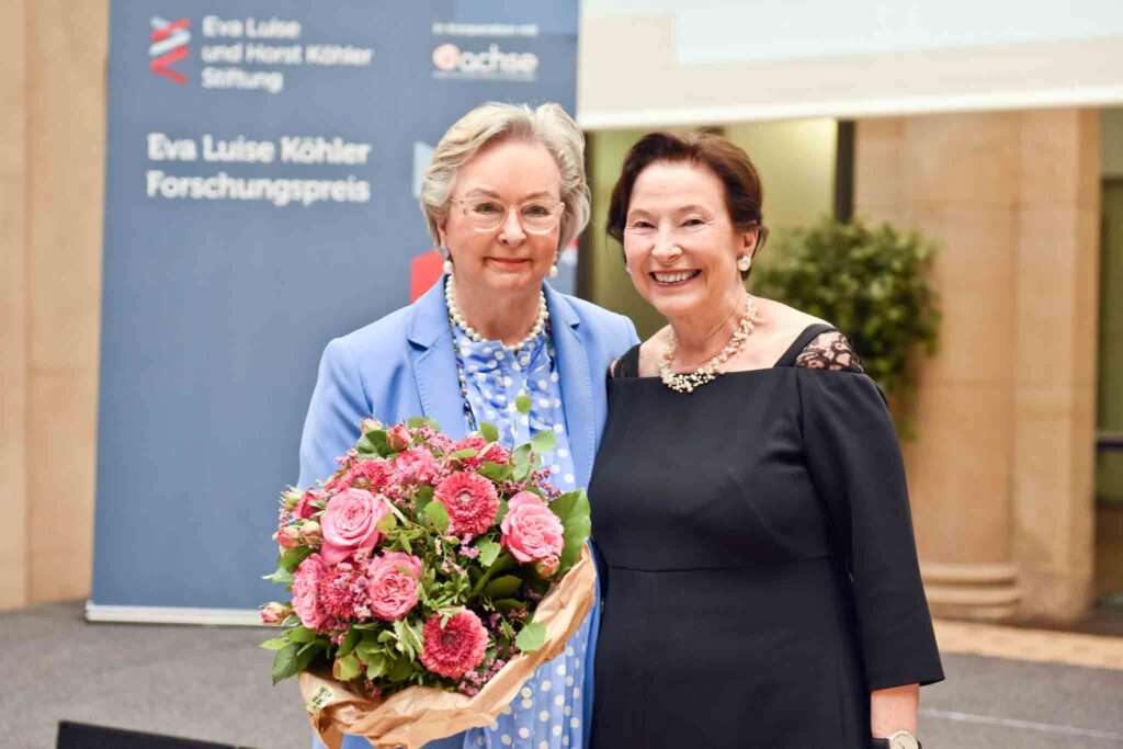 Wera Röttgering mit Blumenstrauß und Eva Luise Köhler vor der Bühne lachen in die Kamera